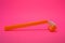 Things, personal care products, disposable, plastic, orange razor, located on pink background.