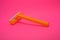 Things, personal care products, disposable, plastic, orange razor, located on pink background.