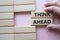 Think ahead symbol. Wooden blocks with words Think ahead. Beautiful pink background. Businessman hand. Business and Think ahead