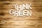 THINK GREEN words made of wooden block letters on wooden board