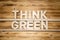 THINK GREEN words made of wooden letters on wooden board.