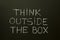 THINK OUTSIDE THE BOX on a blackboard