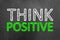 Think positive chalk text on blackboard or chalkboard