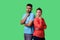 Think up plan! Portrait of smart attractive young couple in casual wear thinking together. isolated on green background