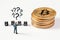 Thinking businessman figurine with question marks above his head looking at cubes next to bitcoin stack