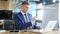 Thinking businessman looking at laptop in his office