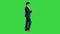 Thinking businessman writing notes in his notebook while walking on a Green Screen, Chroma Key.