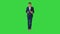 Thinking businessman writing notes in his notebook while walking on a Green Screen, Chroma Key.