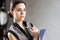 Thinking Caucasian Businesswoman with Notepad Posing with Thoughtful Expression in Studio Environment