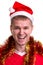 Thinking for christmas gift ideas. Funny smiling guy with a Santa hat and tinsel around the neck. Portrait