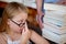 Thinking, concern and a child with books at a library for education, knowledge and learning. Looking, worry and a girl