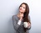 Thinking concerned young woman looking up with cup of coffee