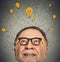 Thinking elderly man with question signs and light idea bulb above head