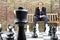 Thinking man sitting at a life sized outdoor chess board