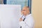 Thinking Mature Doctor Standing Near Flipchart