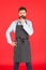 Thinking about new recipe. Elegant waiter man or bartender. Bearded man wearing bib apron. Man cook with beard and