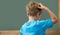 Thinking pupil scratching his head in classroom