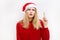 Thinking and reflecting girl in a Christmas hat. Emotional woman in red santa claus hat. Holiday concept. Emotion facial