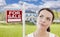 Thinking Woman In Front of House and For Sale Sign