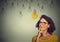 Thinking woman in glasses looking up with light idea bulb above head