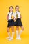 Thirst and dehydration. Healthy nutrition. Schoolgirls holding juice bottle on yellow background. Quenching thirst