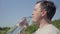 Thirst quenching. Drink clean water from a bottle. A young man of Caucasian appearance drinks water from a transparent