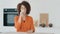 Thirsty African American woman with curly hair girl drinking water standing in kitchen in morning start new day with