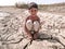 Thirsty child is sitting on dried land