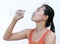 Thirsty fitness girl drinking bottle of water