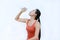 Thirsty fitness girl drinking bottle of water