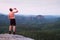 Thirsty hiker in black pants with bottle of water. Sweaty tired tourist on the peak of sandstone rocky park Saxony Switzerland wat