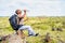 Thirsty man drinking water while sitting on top of hill during trekking - concept of taking break, healthy active