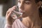 Thirsty young woman holding glass drinking mineral water concept