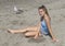 Thirteen year-old girl relaxing on sandy beach with seagull in background