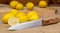 Thirteen yellow lemons on a wooden board and canvas and a knife in the foreground