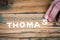 THOMAS. Name of men and boys. Birthday concept. White letters of the alphabet on a wooden background