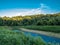 Thornburg Conservation Park in Thornburg, Pennsylvania at golden hour with sunlight casting a glow over the trees and the creek.