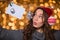 Thoughtful amusing female using handmade christmas decoration over glittering background