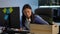 Thoughtful Asian young woman sitting at computer in office taking box with staff leaving. Portrait of fired confident