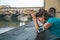 Thoughtful athletic female staying next to Ponte Vecchio bridge