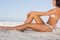 Thoughtful attractive woman in white bikini posing while sitting