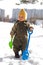 Thoughtful baby with shovels against buildings