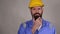Thoughtful bearded middle age man in hard hat in the helmet touching his beard and thinking thoughts with smart face