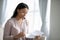 Thoughtful biracial woman reading postal letter at home