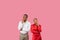 Thoughtful black couple with hand on chins looking up at free space, pink backdrop