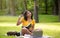 Thoughtful black girl with notebook and laptop making difficult assignment at park