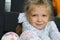 Thoughtful blonde little girl sitting on floor