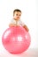 Thoughtful boy with pink fitness ball