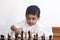 Thoughtful boy playing chess. A little middle eastern boy plays chess. Thinking on find the best move