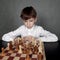 Thoughtful boy playing chess, studio